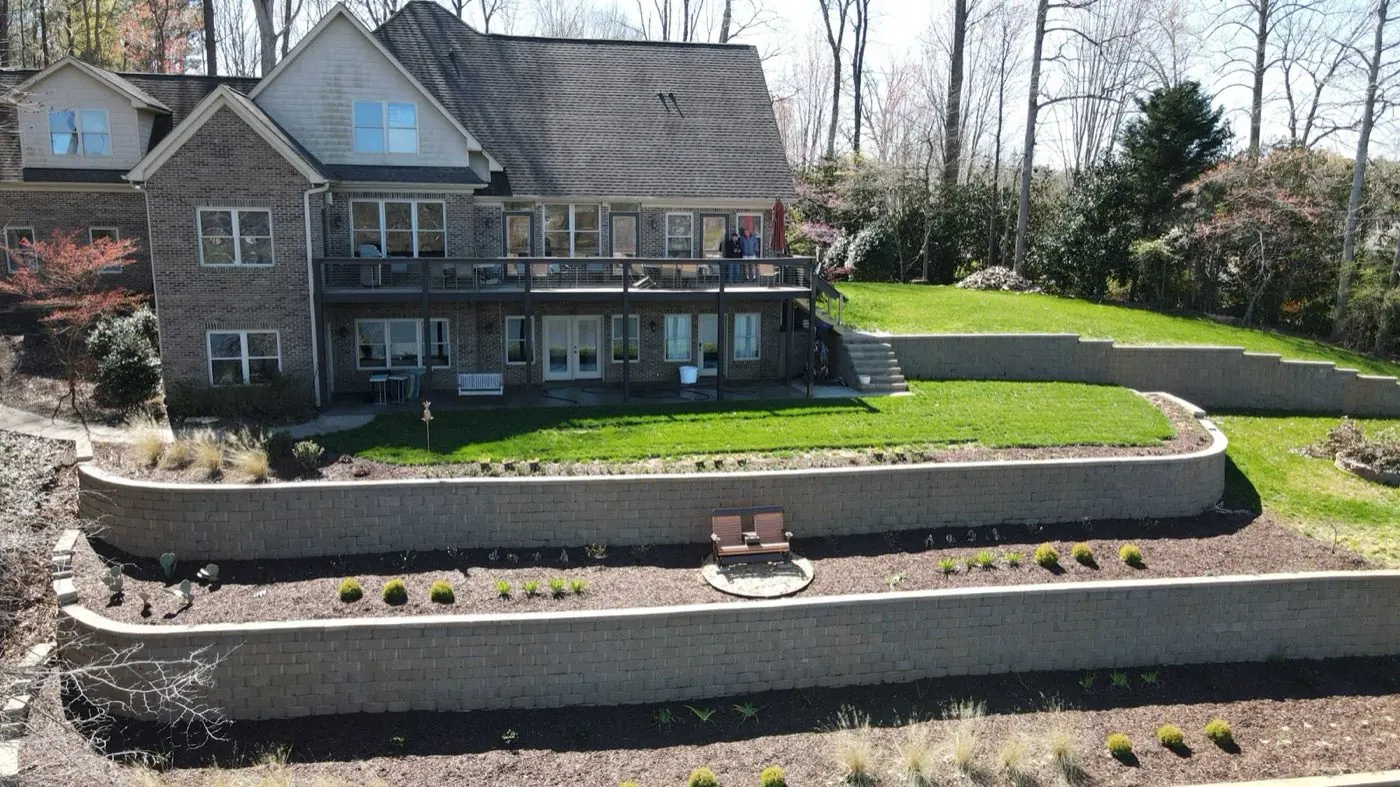 Terraced block retaining wall with planted beds on a Mooresville property